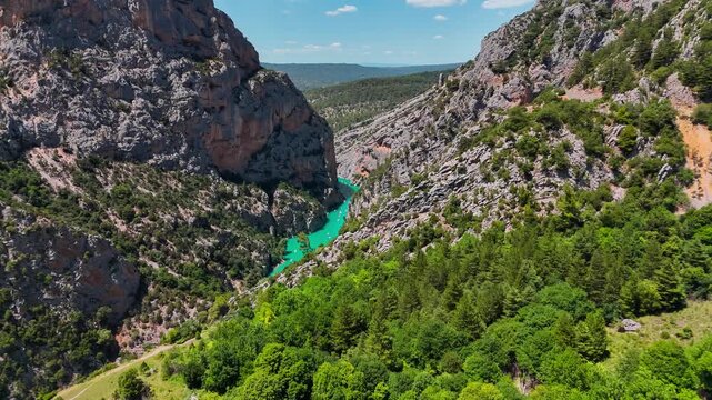 Aerial drone view of the turquoise Verdon River flowing through the Verdon Gorge river canyon in the Provence-Alpes-Cote d'Azur region of southeastern France. High quality 4k footage
