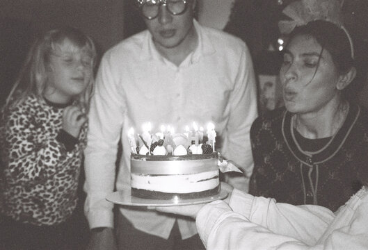 Family Members Celebrate a Birthday With a Cake and Candles
