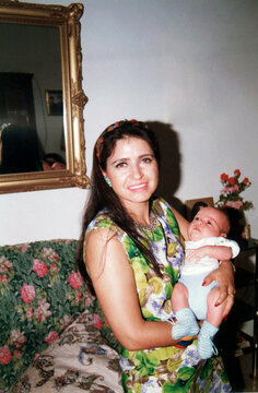 Mother smiling holding her baby close at home