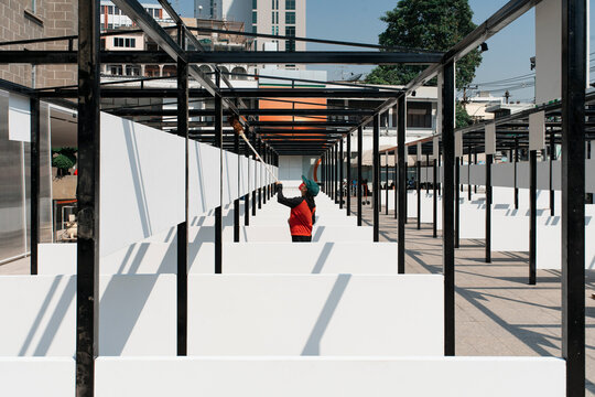 Worker painting booths at an empty open market space during the day