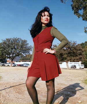 Confident young woman standing outdoors modeling vintage fashion