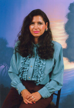 Woman wearing ruffled blouse posing in retro studio