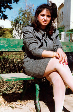 Woman wearing grey dress sitting on park bench