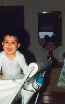 Happy baby sticking tongue out in playpen