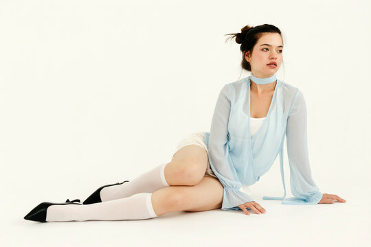 Woman lying down on white studio background