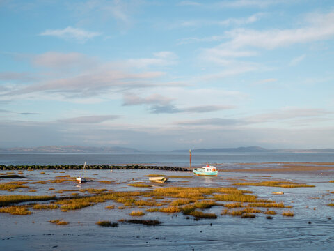 Small boats on tidal mudflat at low tide in Morecambe
