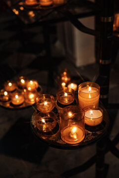 Candles Are Lit on Different Stands in a Dim Space During Evening