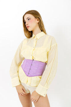 Woman modeling fashion outfit with purple corset