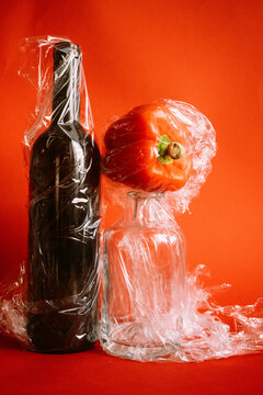 Creative setup with a bottle, a glass, and a pepper wrapped