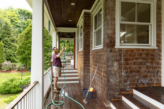 Spring Window water hose  Clean man on ladder 