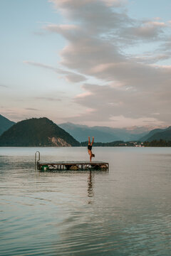 Teenager performing handstand on a floating platform 