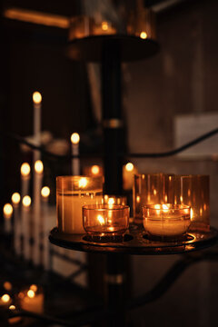 Candles Are Lit on Different Stands in a Dim Space During Evening