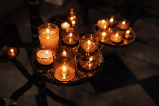 Candles Are Lit on Different Stands in a Dim Space During Evening