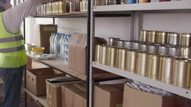 Humanitarian Emergency Supply Warehouse with Food and Essential Goods During Crisis. Shelves with food, canned food, cereals, nuts, water, medicines,boxes, clothes