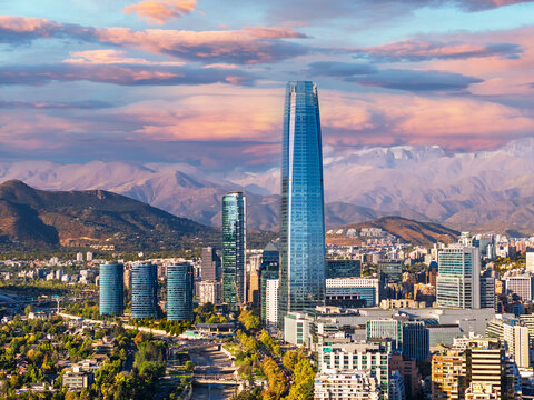 Aerial view of Santiago city skyline with skyscraper and Andes mountains in the background at sunset, Chile