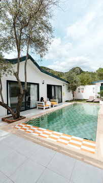 Tropical Villa Retreat: A secluded villa features a pristine swimming pool, surrounded by lush greenery and modern architecture, offering a serene escape in a picturesque setting.
