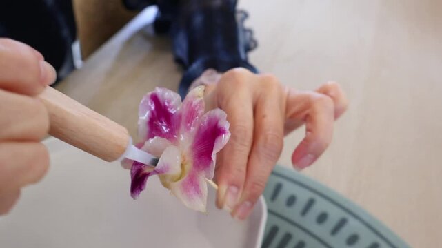 Hand Applying Resin on Orchid Flower in Multiple Layers during Crafting Process of DIY Workshop