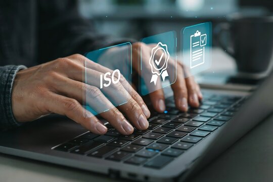 Person typing on laptop with digital iso certification and quality management system icons