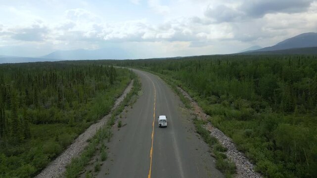 Camper van drone aerial view driving remote road through Yukon wilderness in Canada
