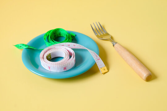 Measuring tape on dish with fork,Diet concept.