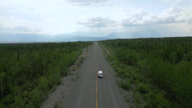 Camper van drone aerial view driving remote road through Yukon wilderness in Canada
