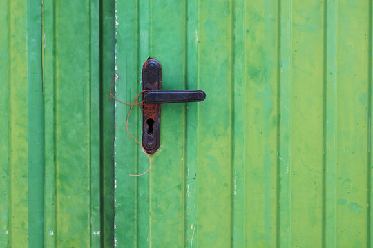 Old green metal door with lock and keyhole, closeup of photo