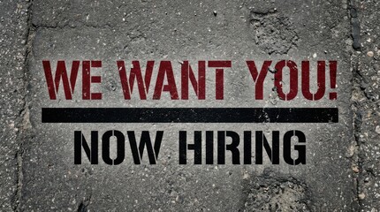 Naklejka premium We want you now hiring text painted on rough asphalt road surface with cracks and stones, top view.