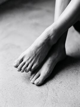Bare feet on textured concrete floor in black and white