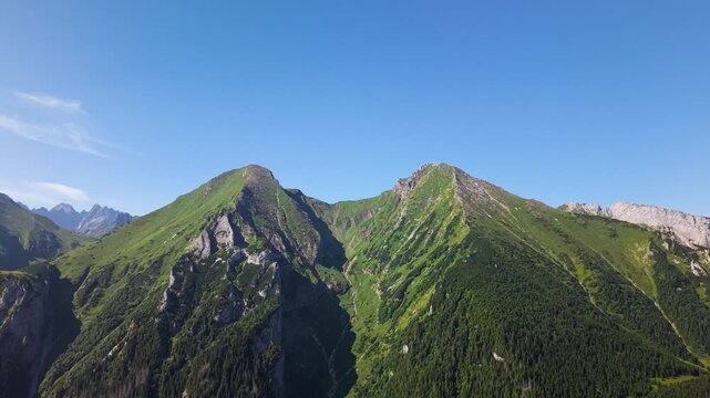 Aerial footage of the Belianske Tatry in Slovakia, featuring the mountain peaks Zdiarska Vidla and Havran. The view captures the dramatic ridgelines, rocky slopes and green alpine landscape