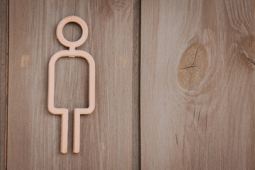 Fototapeta premium Simple wooden figure of a person mounted on a rustic wooden wall, showcasing minimalist design and natural textures in a contemporary setting