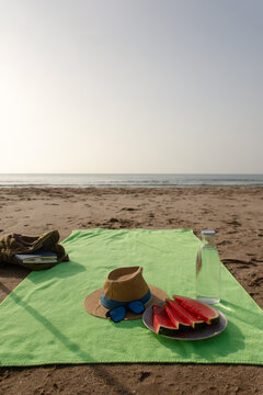 Vertical beach towel with book watermelon and fresh water by sea
