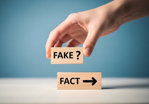 A hand placing a wooden block with the word fake above another block labeled fact to illustrate the concept of misinformation
