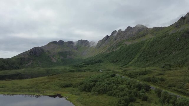 drone of road heading to a mountain in clouds in lofoten norway