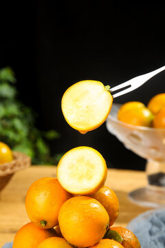 Fresh Kumquats with Sliced Piece on Fork Showing Interior - Citrus Fruit Food Photography