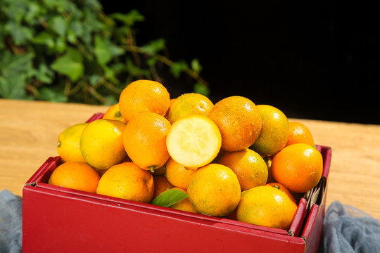Fresh Golden Longan Fruits in Red Wooden Crate - Tropical Asian Fruit Harvest with Smooth Honey-Colored Skin