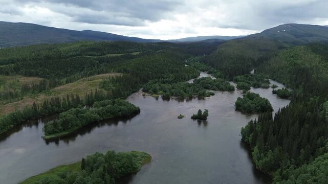Lake in Norway with green forest and cloudy skies