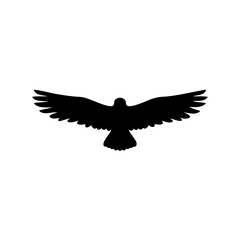 Fototapeta premium Black silhouette bird in flight - Minimalist black silhouette of a bird captured mid-flight with outstretched wings against a clean background.