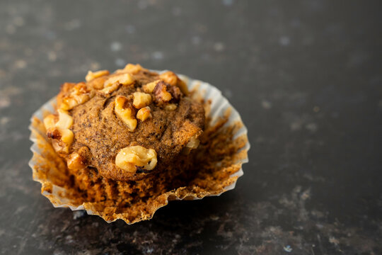 Banana muffins in paper liners sprinkled with walnuts 