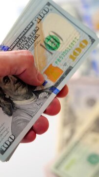 Male hands counting US Dollar bills, close-up