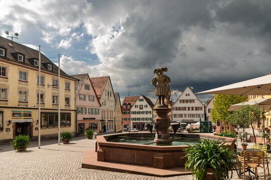 Market square fountain beneath dramatic storm clouds in the historic centre of Weil der Stadt, Baden-W&uuml;rttemberg, Germany.