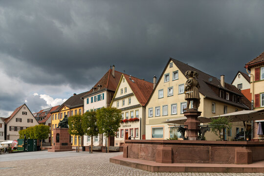 Wide view of market square with fountain and approaching storm clouds in historic Weil der Stadt, Baden-W&uuml;rttemberg, Germany.