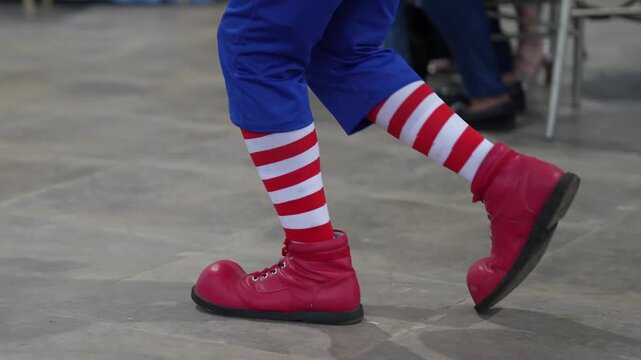 Clown with colorful shoes walking super slow plus slow motion.