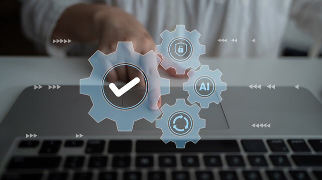 A person interacts with a laptop in a modern workspace, with digital gears and symbols representing technology, automation, and artificial intelligence prominently displayed. Gantry