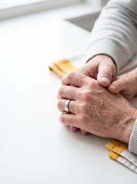 Close Up of Elderly Couple Holding Hands with Wedding Ring, Symbolizing Love, Support and Growing Old Together