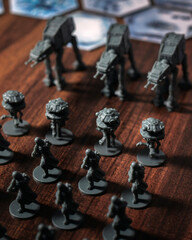 Fototapeta premium Imperial army miniatures assembled on a Battle of Hoth tabletop battlefield featuring AT AT walkers, scout droids and infantry captured with dramatic lighting in a cinematic perspective