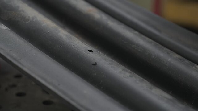 A worker drills holes in a rubber ski of a snowmobile for subsequent attachment to the frame.