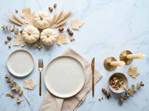 Elegant thanksgiving table setting with white pumpkins dried leaves and candles on light background