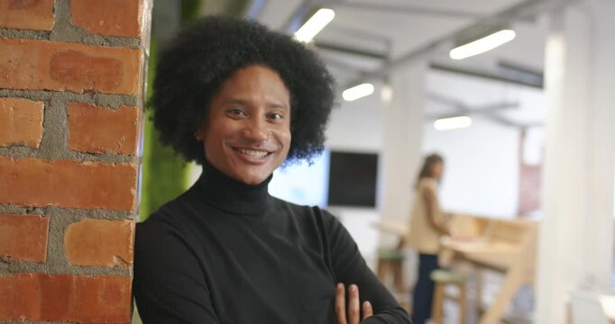 Diverse coworkers at office adult male leaning brick column smiling while camera zooming for shot