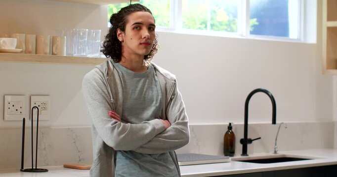 African American adult male turning and smiling, straightening at kitchen counter near black faucet