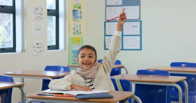 After finishing book African American girl raising hand with pink pencil signaling teacher in class